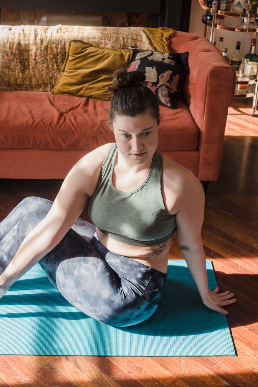 Person stretching with a calm expression in a sunlit room.